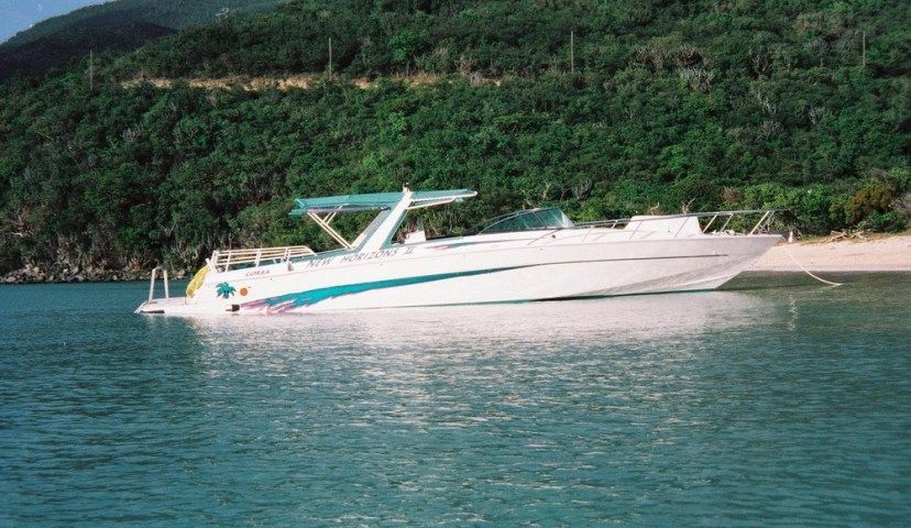 A white boat is floating on top of a body of water.