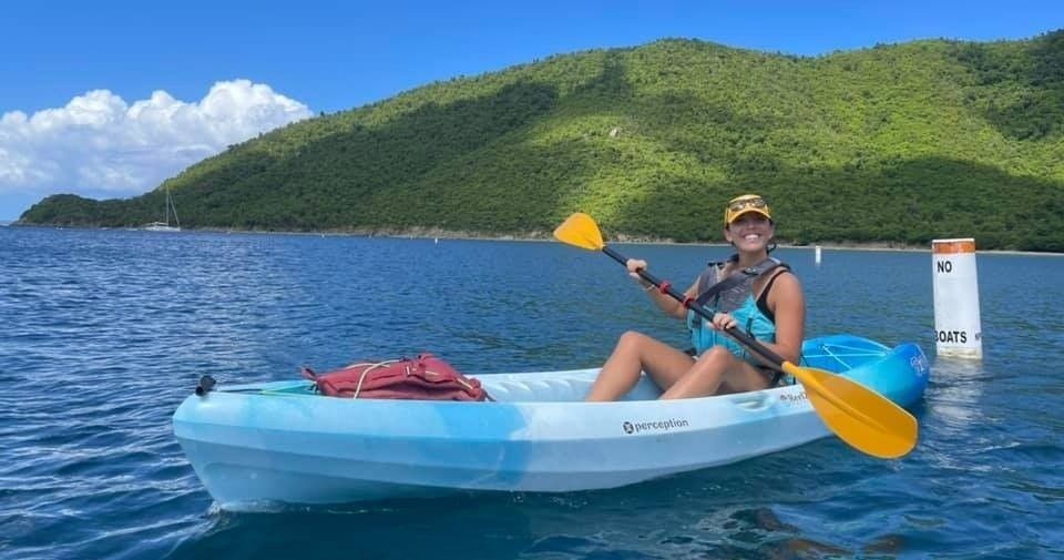 A woman is sitting in a kayak in the water.