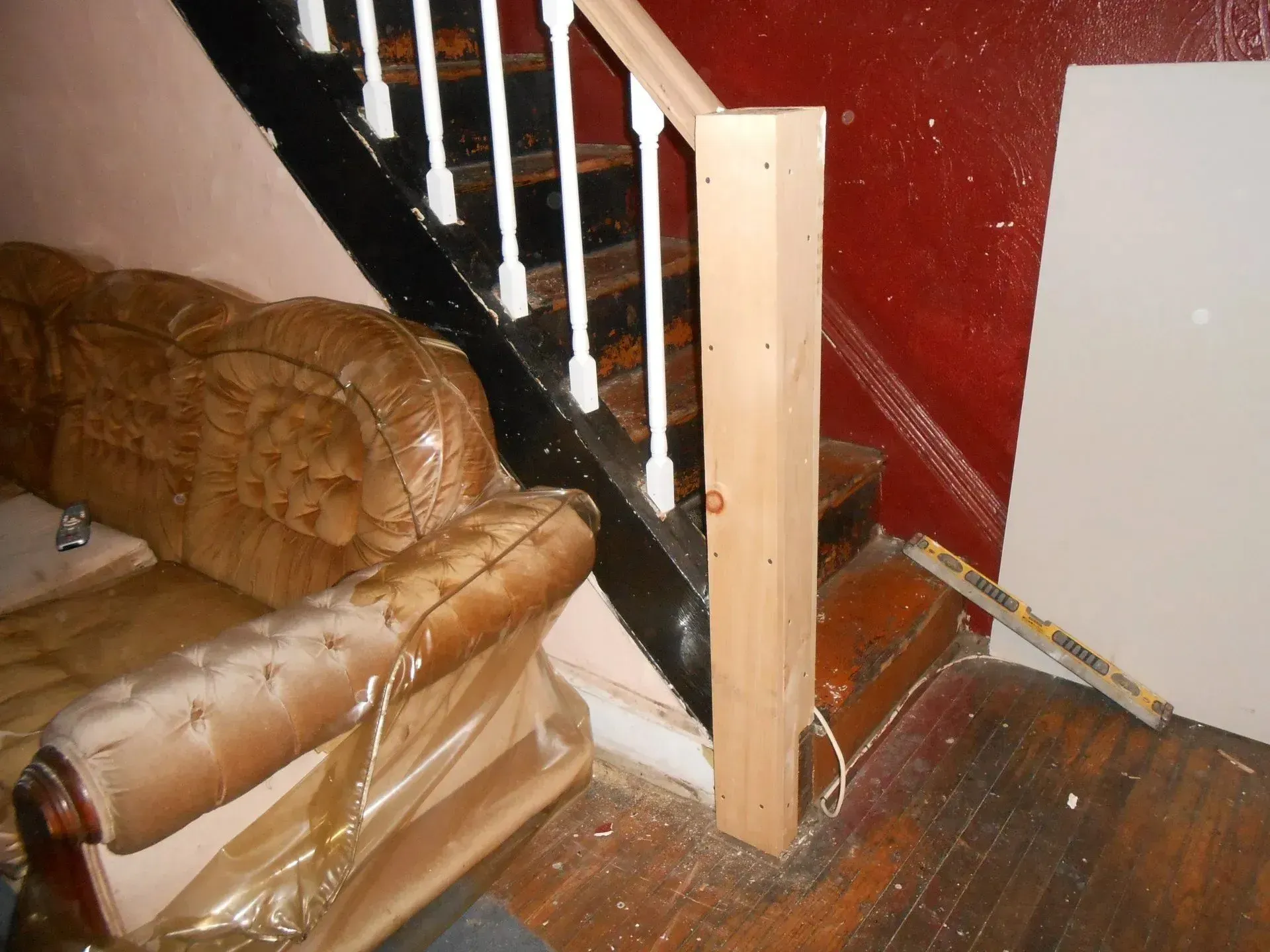 A staircase with a wooden railing and a brown couch
