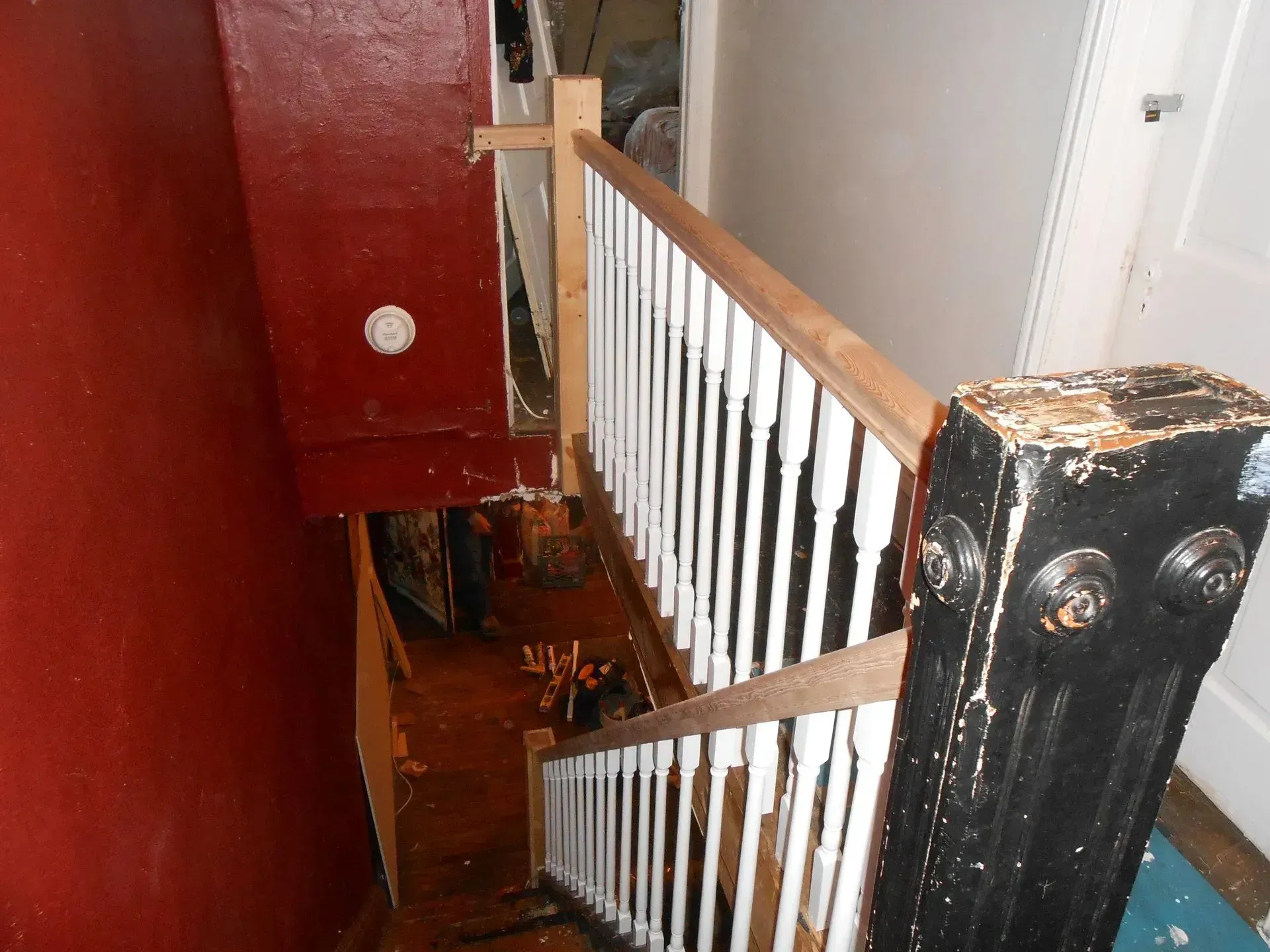 A staircase with a white railing and a black post
