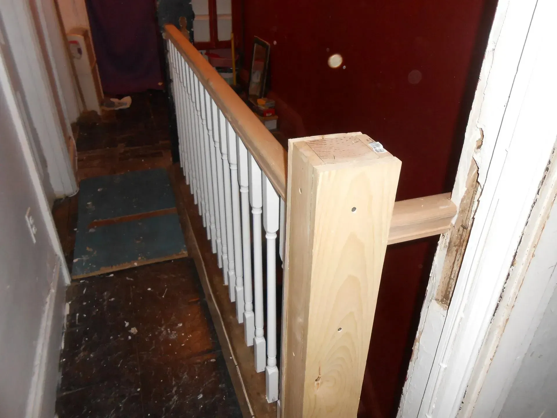 A wooden railing in a hallway next to a door