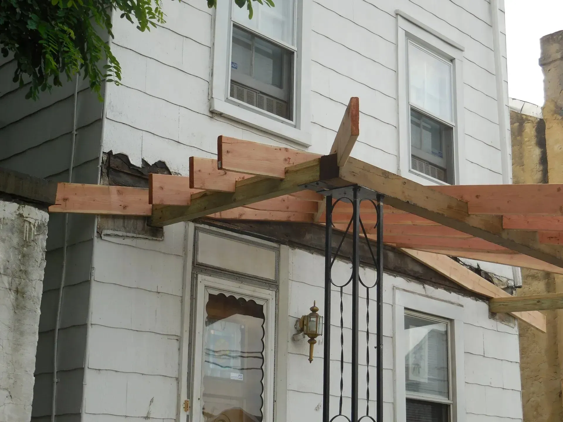 A white house with a wooden pergola in front of it
