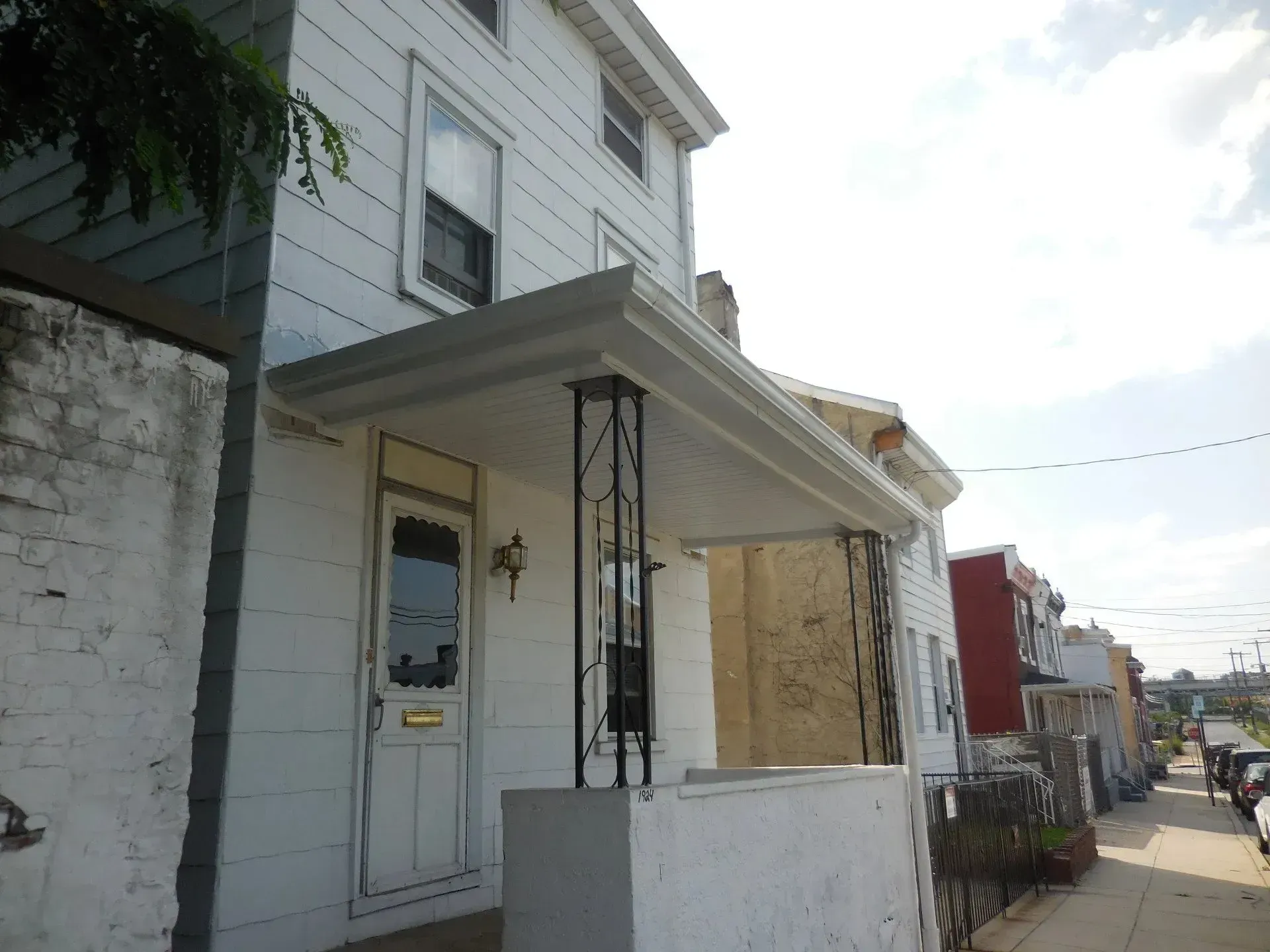 A white house with a porch on the side of it