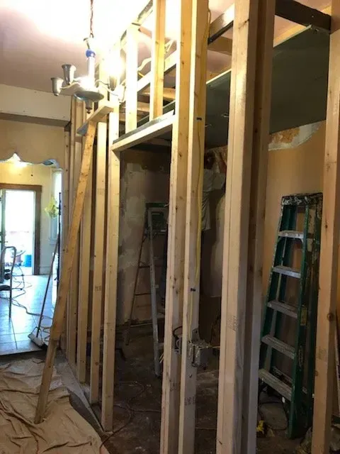 A ladder is sitting in the middle of a room under construction.