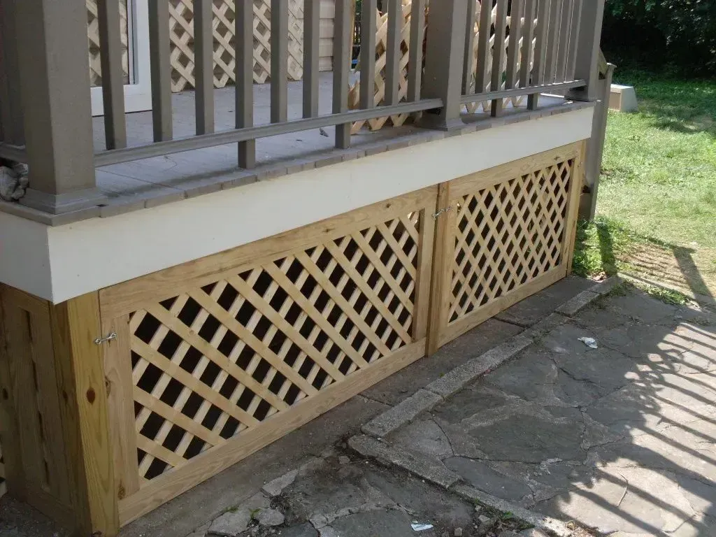 A porch with a wooden lattice on the side of it