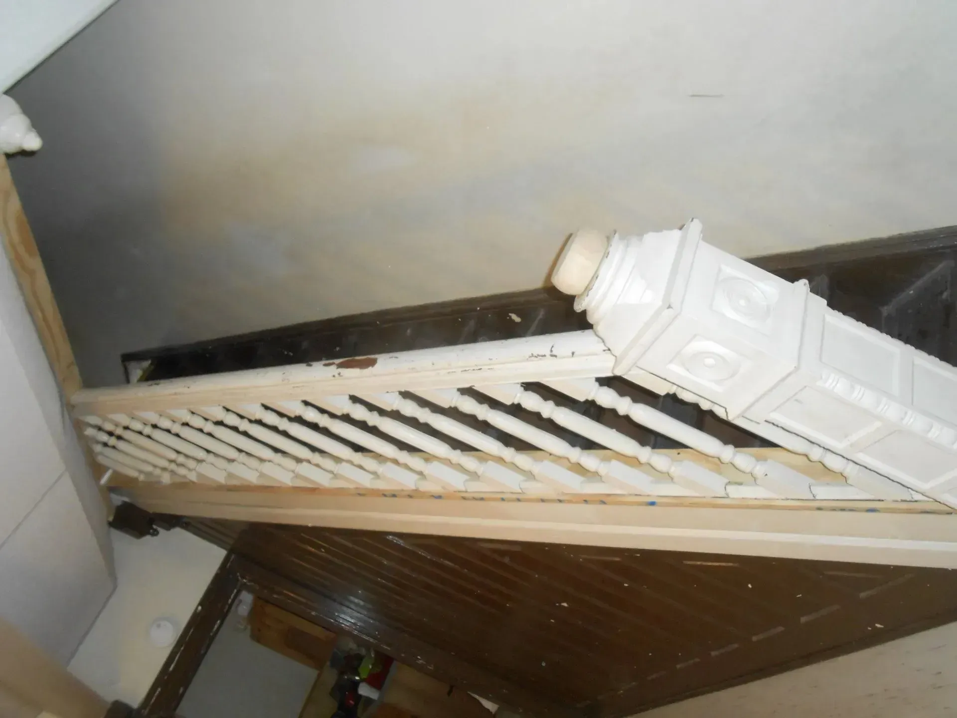 A staircase with a white railing that looks like a clock tower