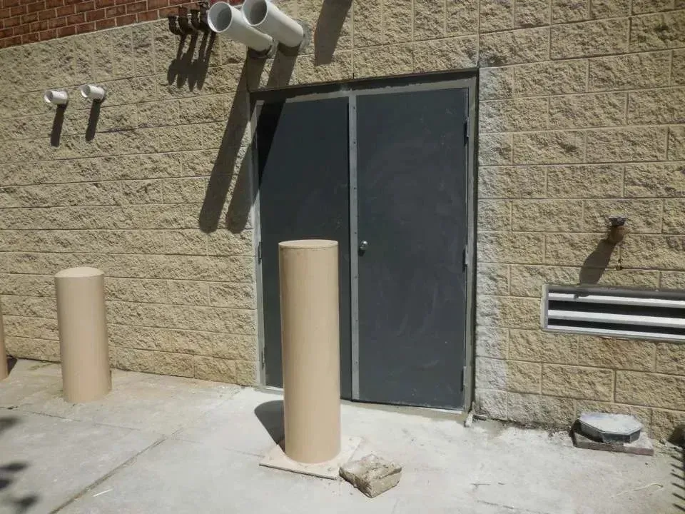 A brick building with a door and two pillars in front of it