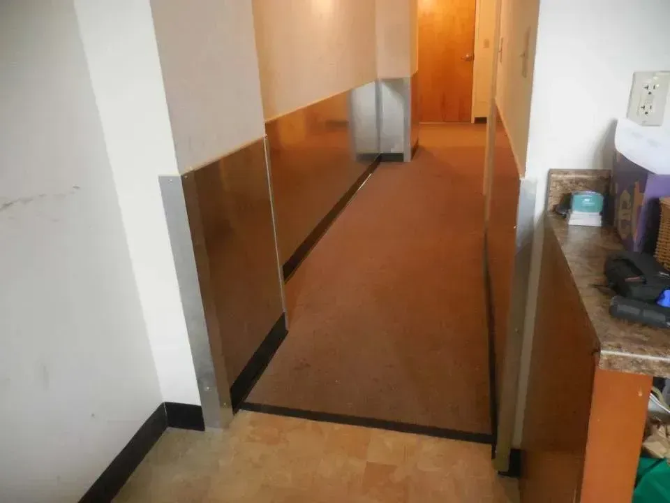 A hallway with stainless steel walls and a brown carpet
