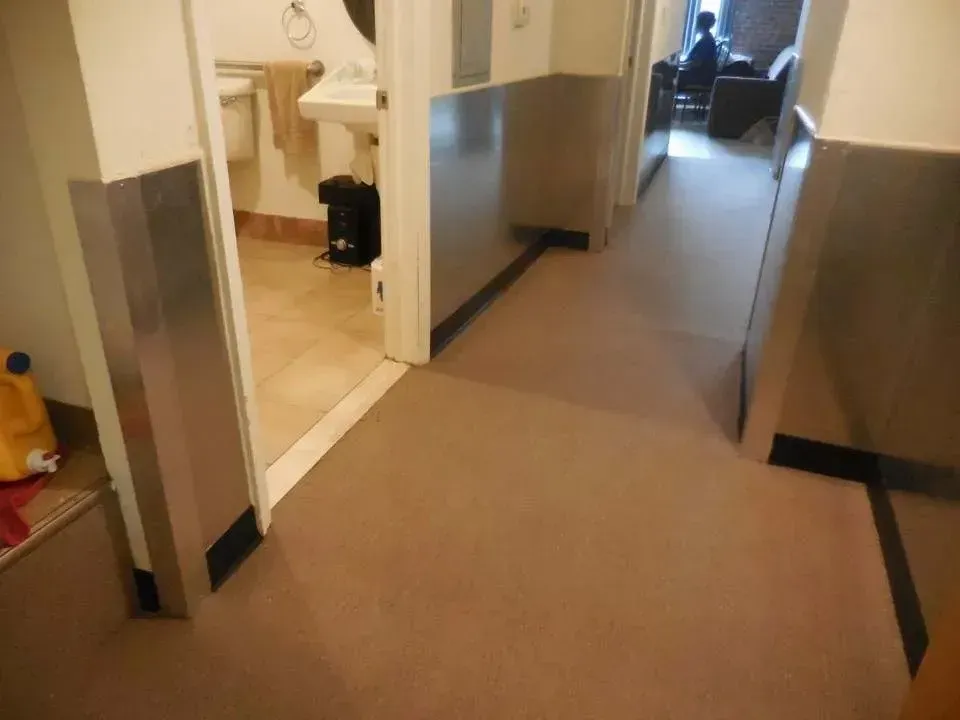 A hallway leading to a bathroom and a living room