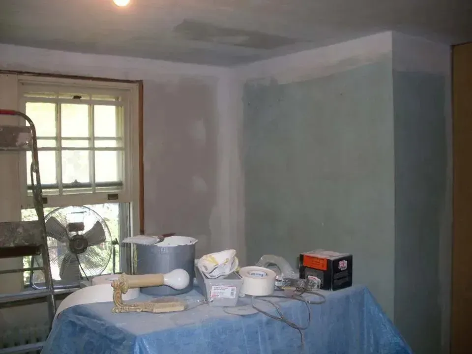 A room with a table and a fan in it