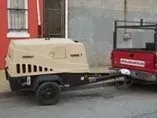 A trailer is being towed by a red truck.