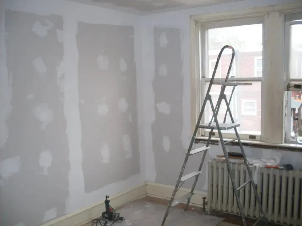 A room with a ladder and a radiator in it