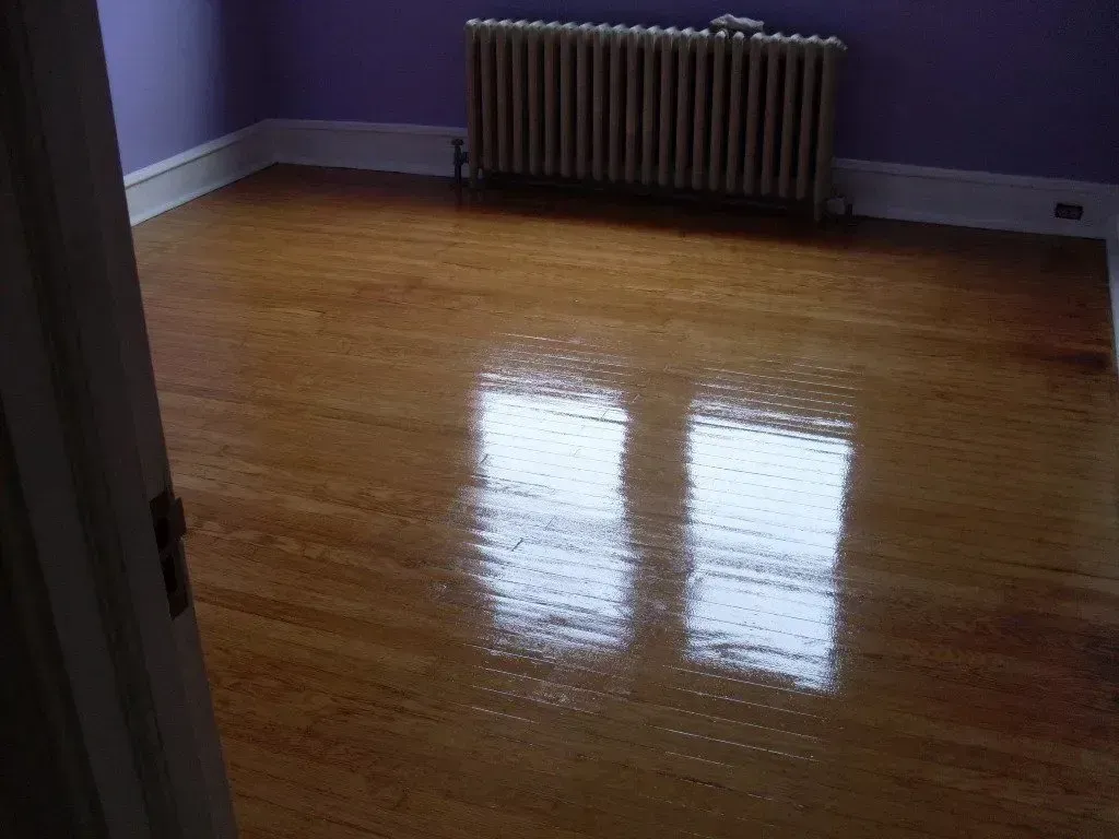 A room with a wooden floor and a radiator