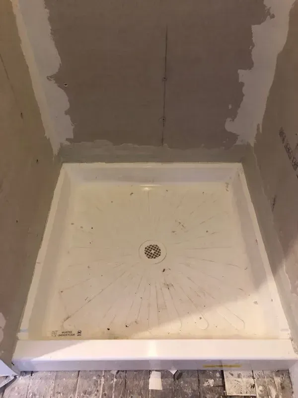 A shower stall is being built in a bathroom.
