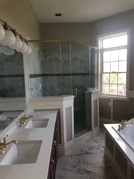 A bathroom with two sinks , a tub and a walk in shower.