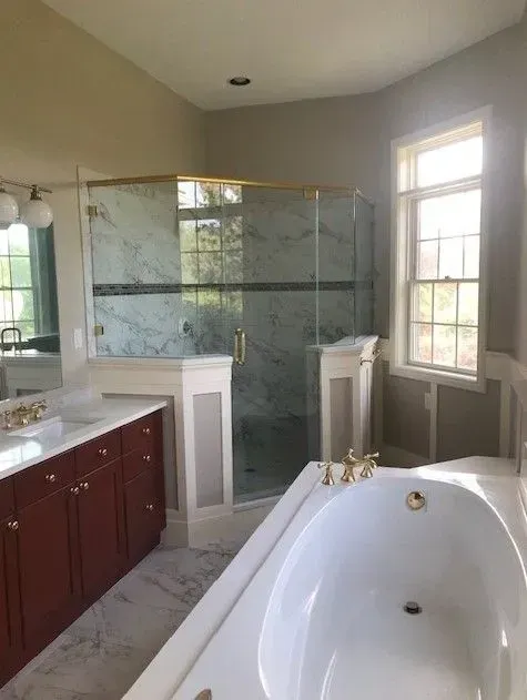 A bathroom with a tub , sink , shower and window