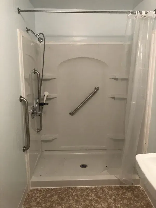 A bathroom with a walk in shower and a toilet.