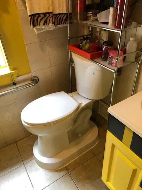A toilet in a bathroom next to a window