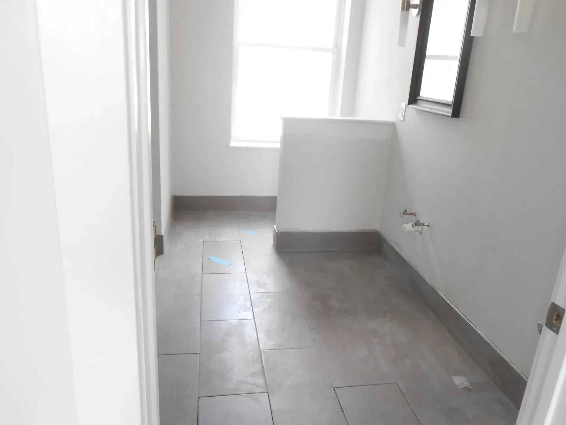 A hallway with a window and a tiled floor