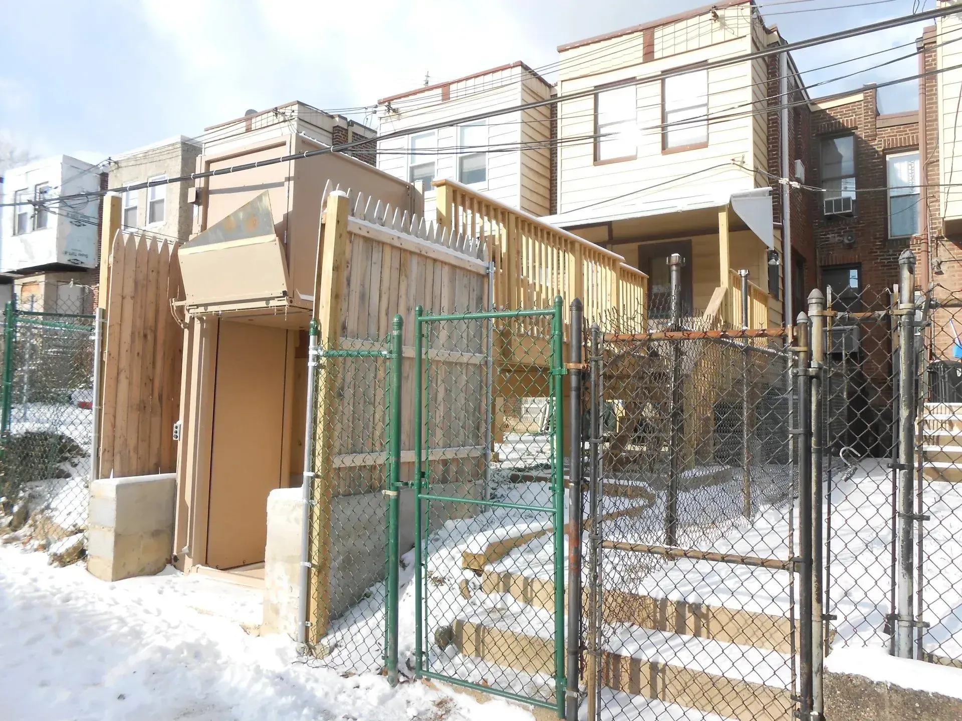 A chain link fence surrounds a building in the snow