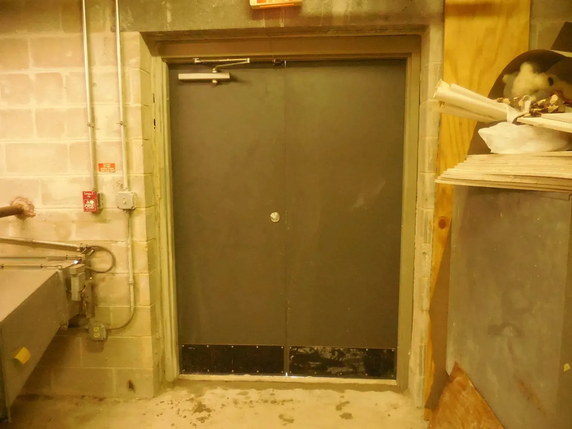 A door is open in a room with a brick wall.