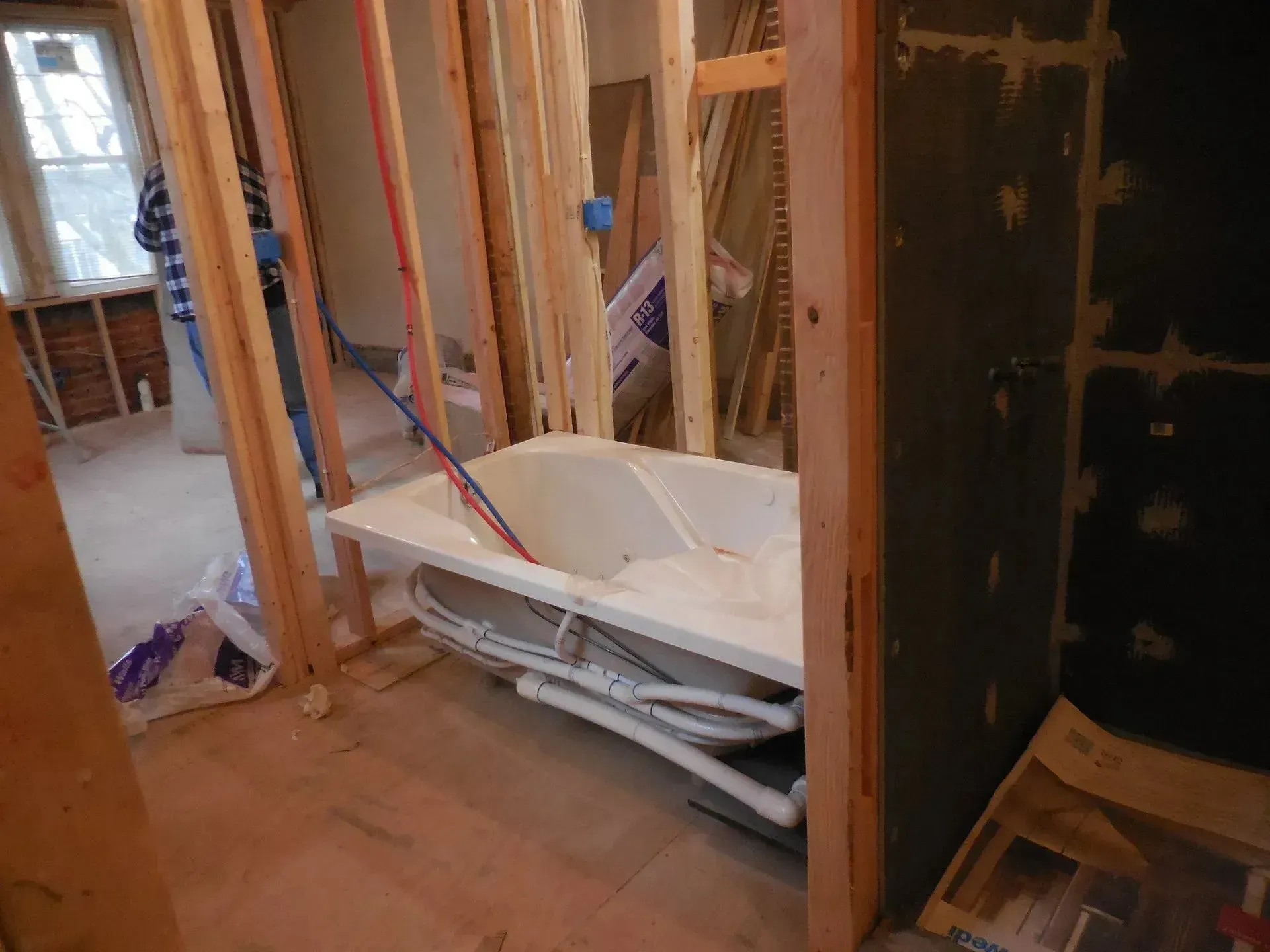 A bathtub is sitting in a room under construction.