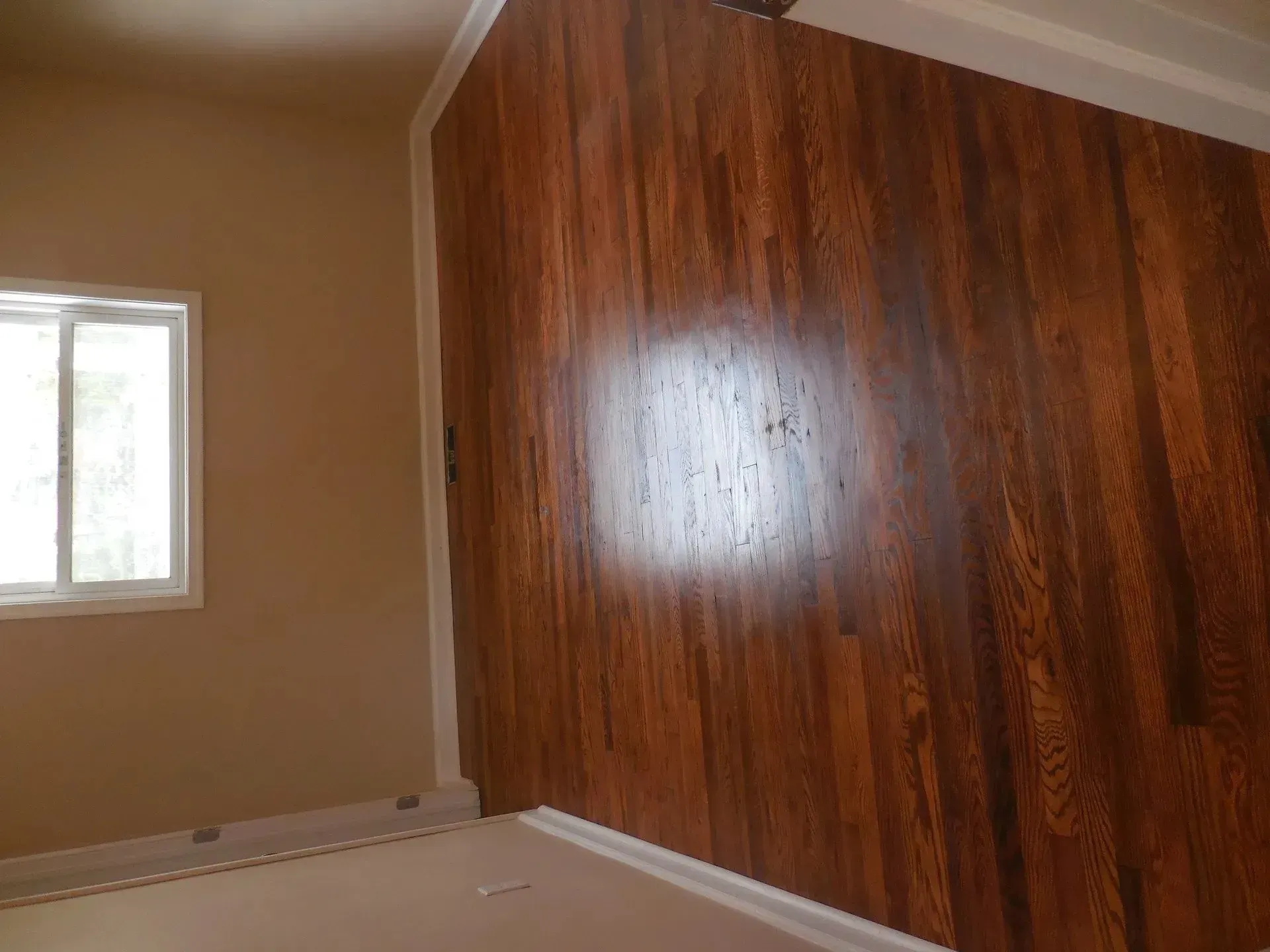 A room with hardwood floors and a window.