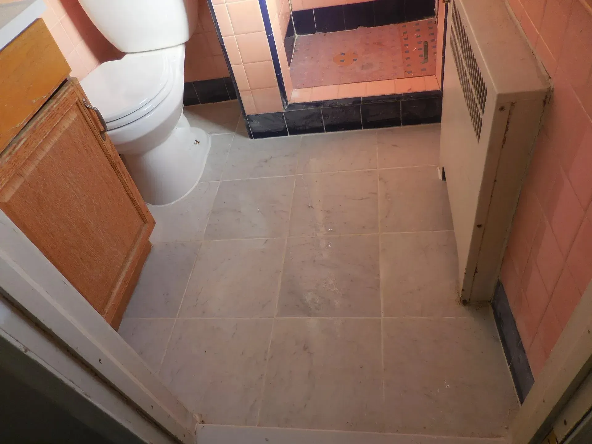 A bathroom with a toilet a sink and a heater