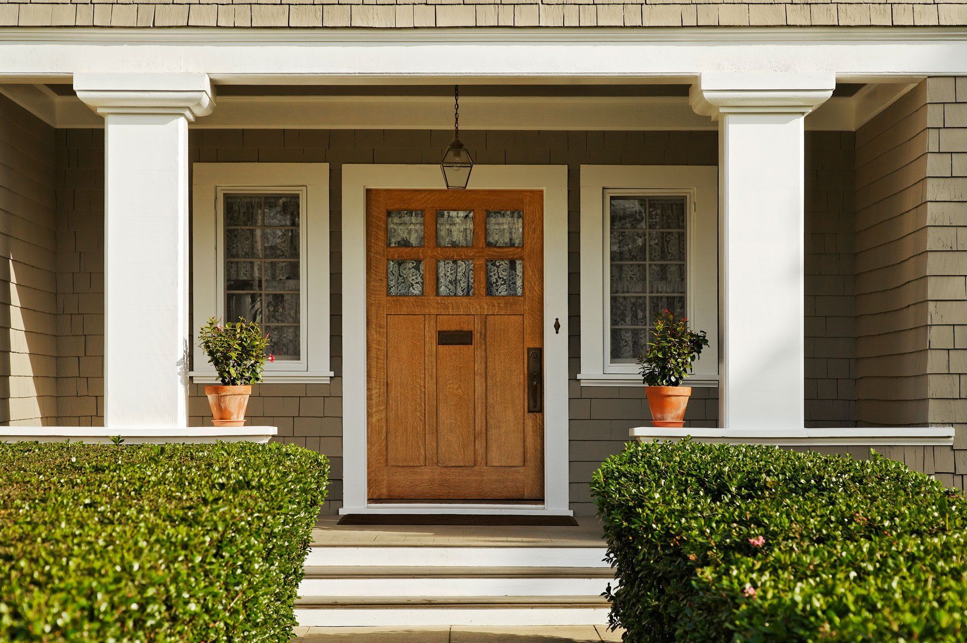 The front door of a brick house with a wooden door