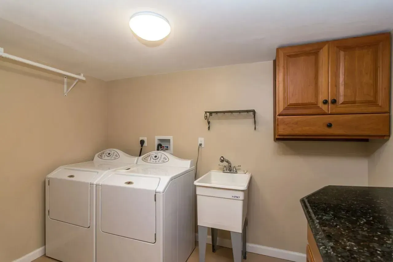 A laundry room with a washer and dryer and a sink.