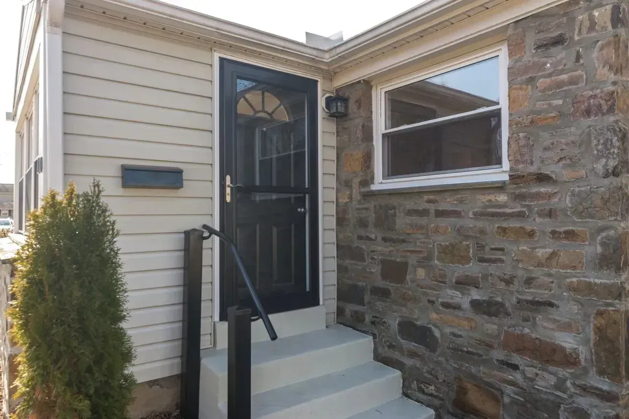 A house with a black door and white siding