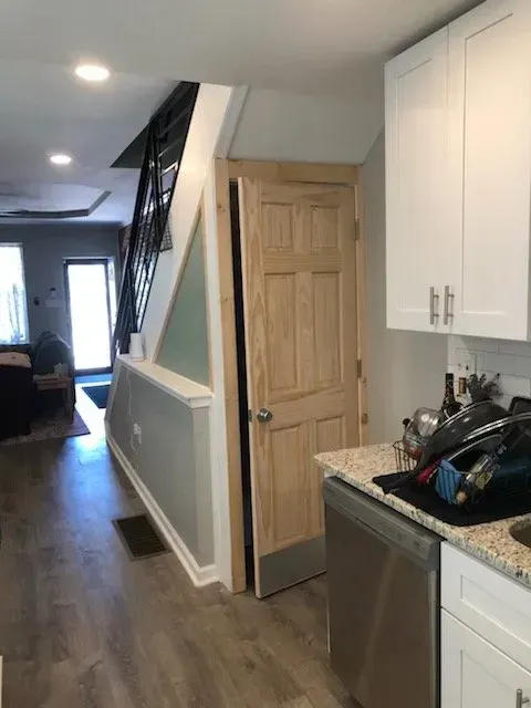 A kitchen with white cabinets and a stainless steel dishwasher