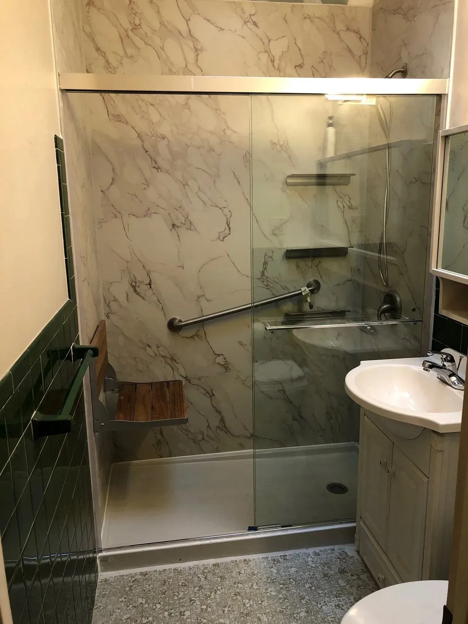 A bathroom with a walk in shower , sink and toilet.