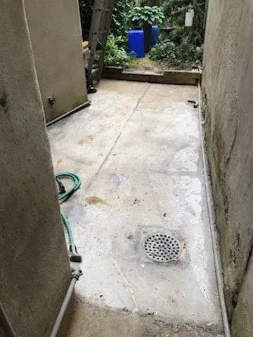 There is a drain on the floor in the backyard.