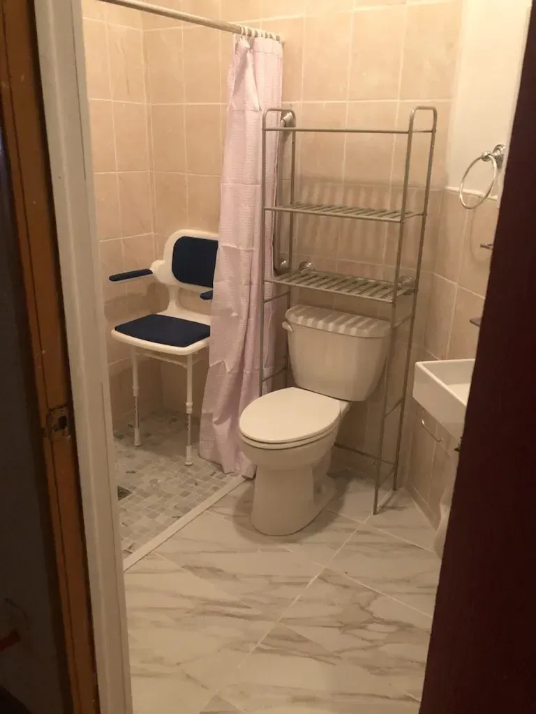 A bathroom with a toilet , sink and shower curtain.