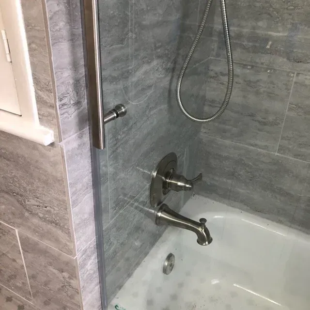 A bathroom with a bathtub and a shower.