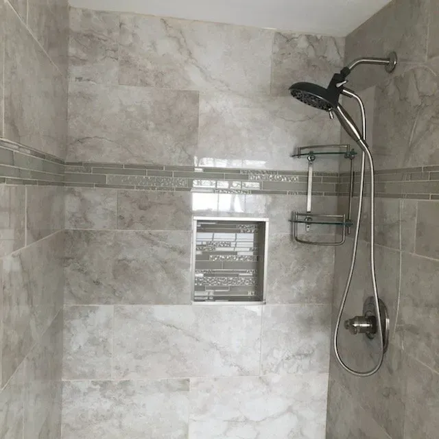 A shower with marble tiles and a shower head