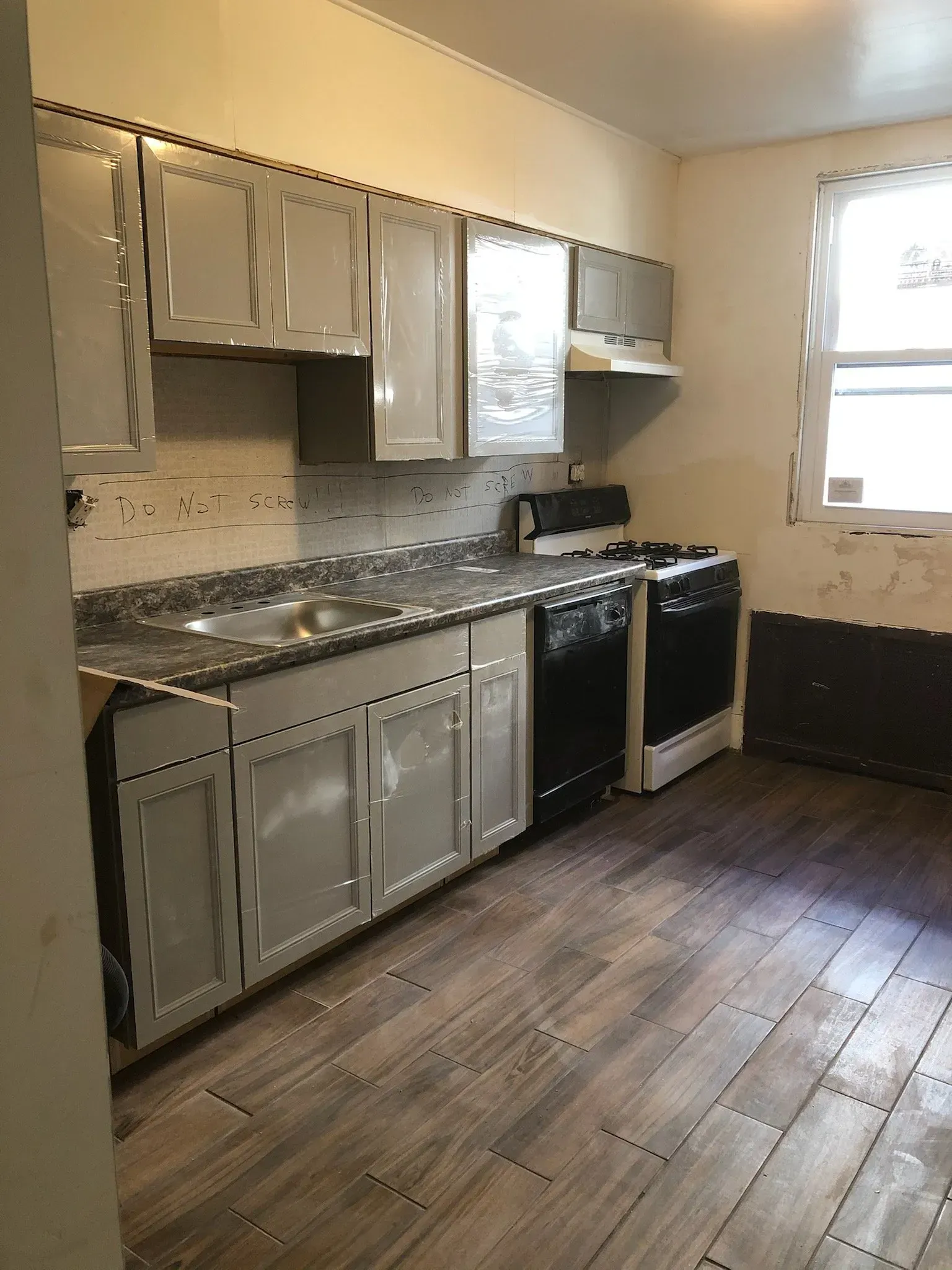 A kitchen with a stove , sink , and dishwasher.