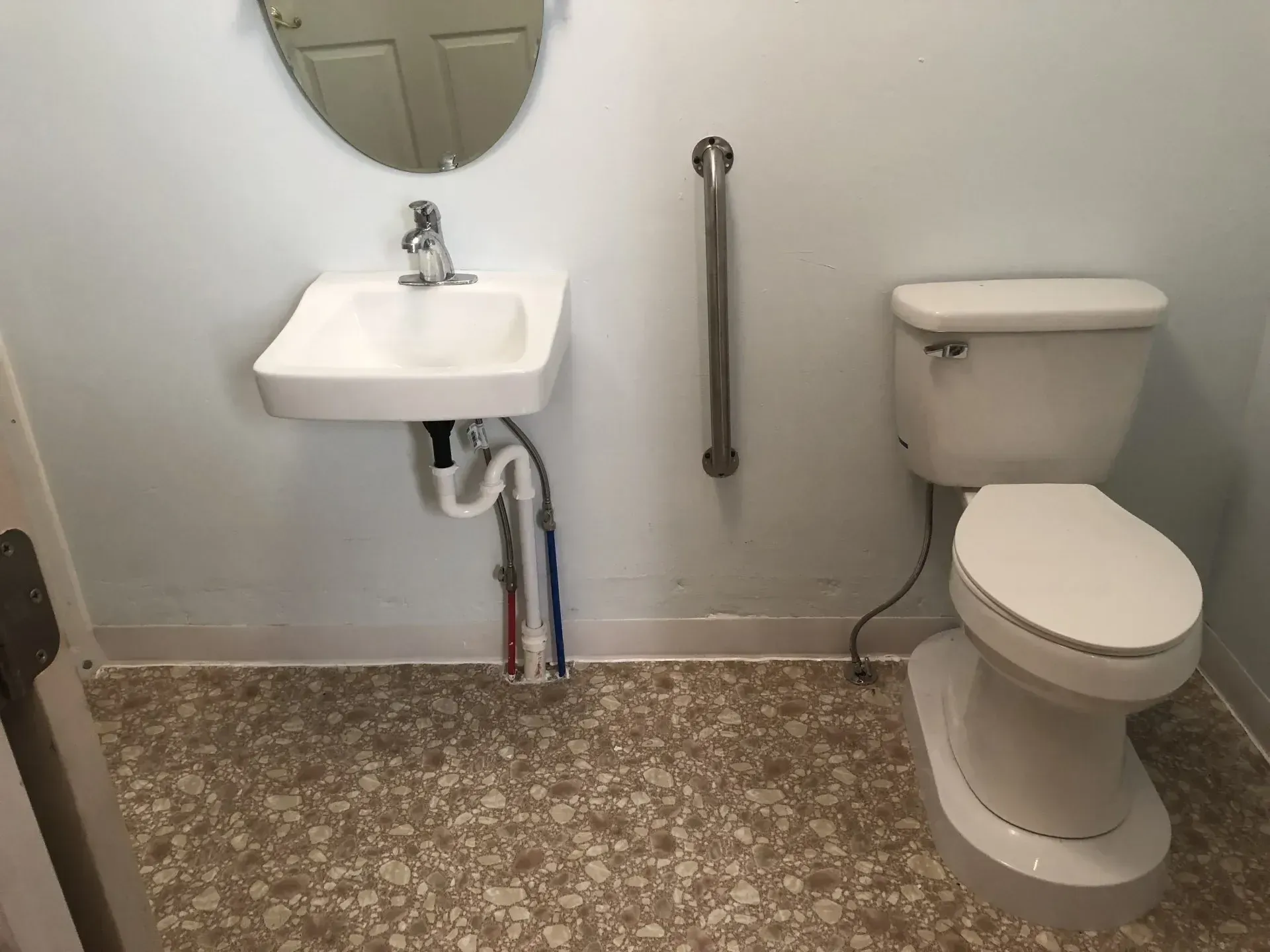 A bathroom with a toilet a sink and a mirror