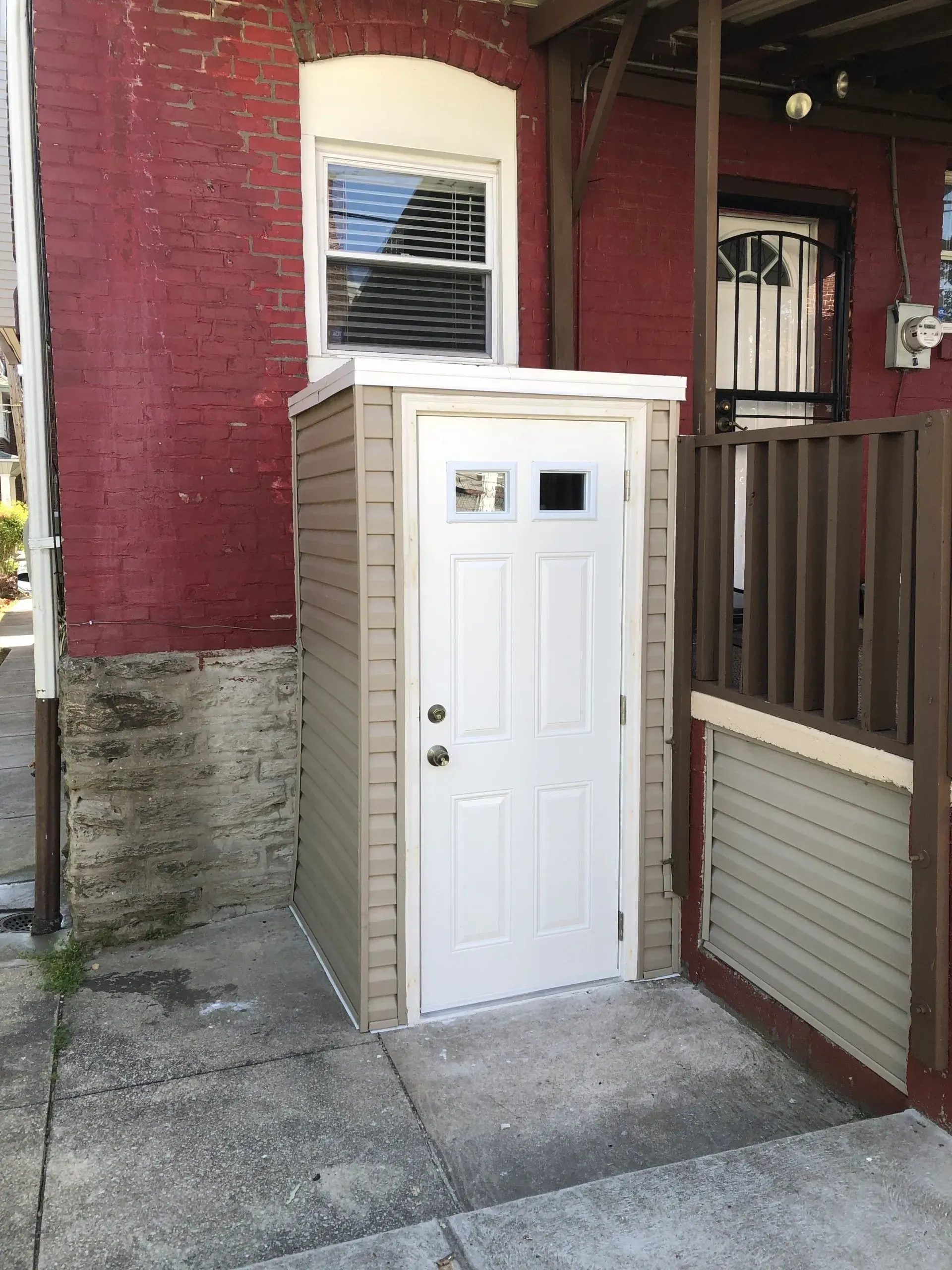A red brick building with a white door in front of it