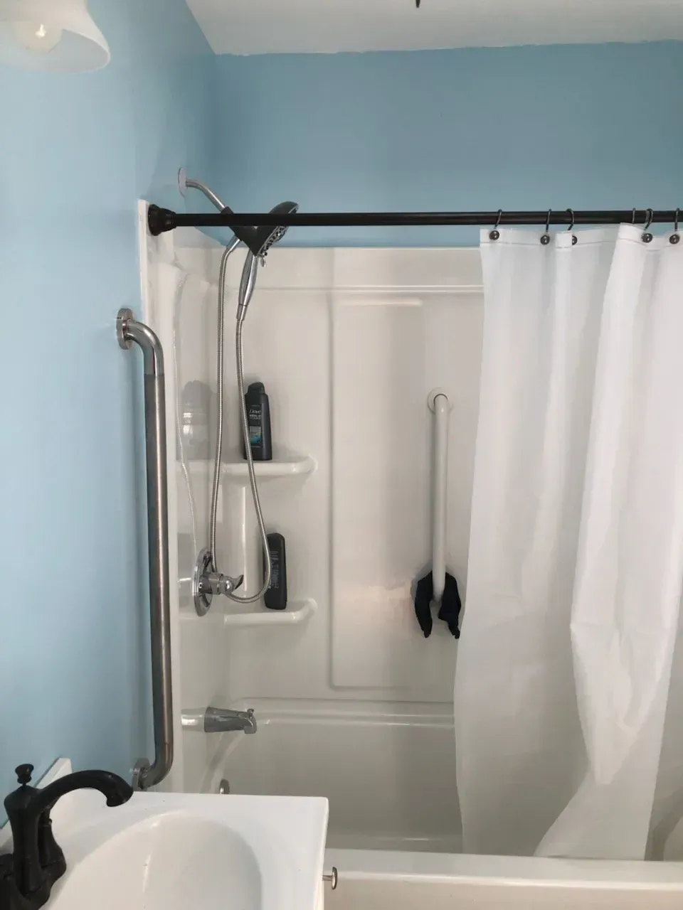 A bathroom with blue walls and a white shower curtain
