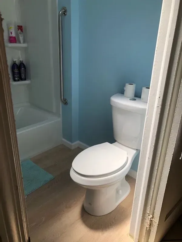 A bathroom with a toilet , tub and shower.