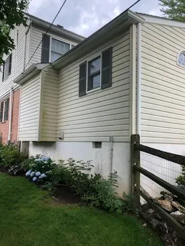 A white house with a wooden fence in front of it.