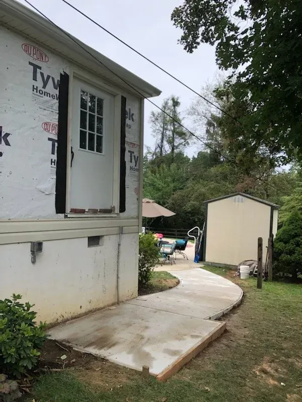 A white house with a concrete walkway leading to it