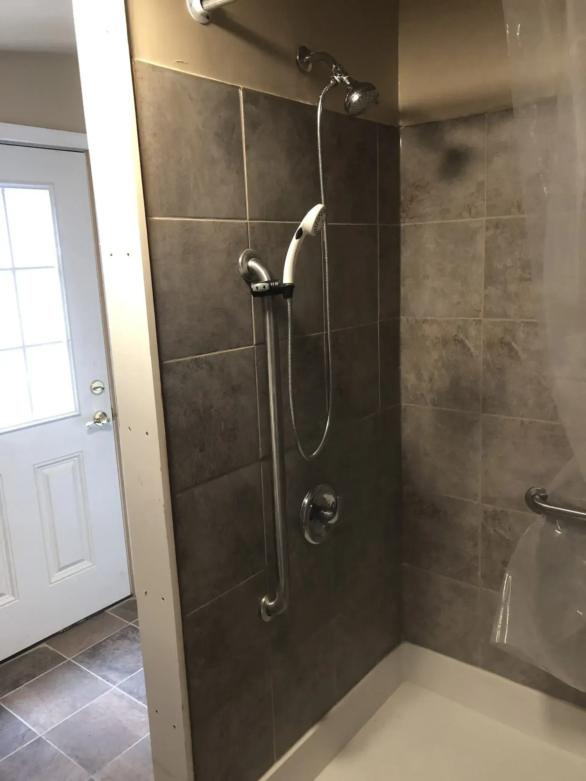 A bathroom with a walk in shower and a tub.