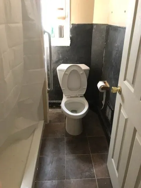 A bathroom with a toilet and a shower stall