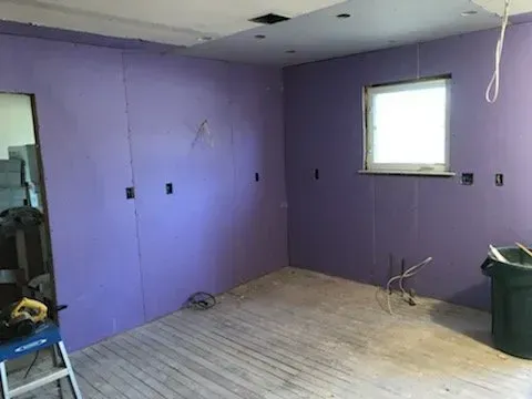 A room with purple walls and a window.