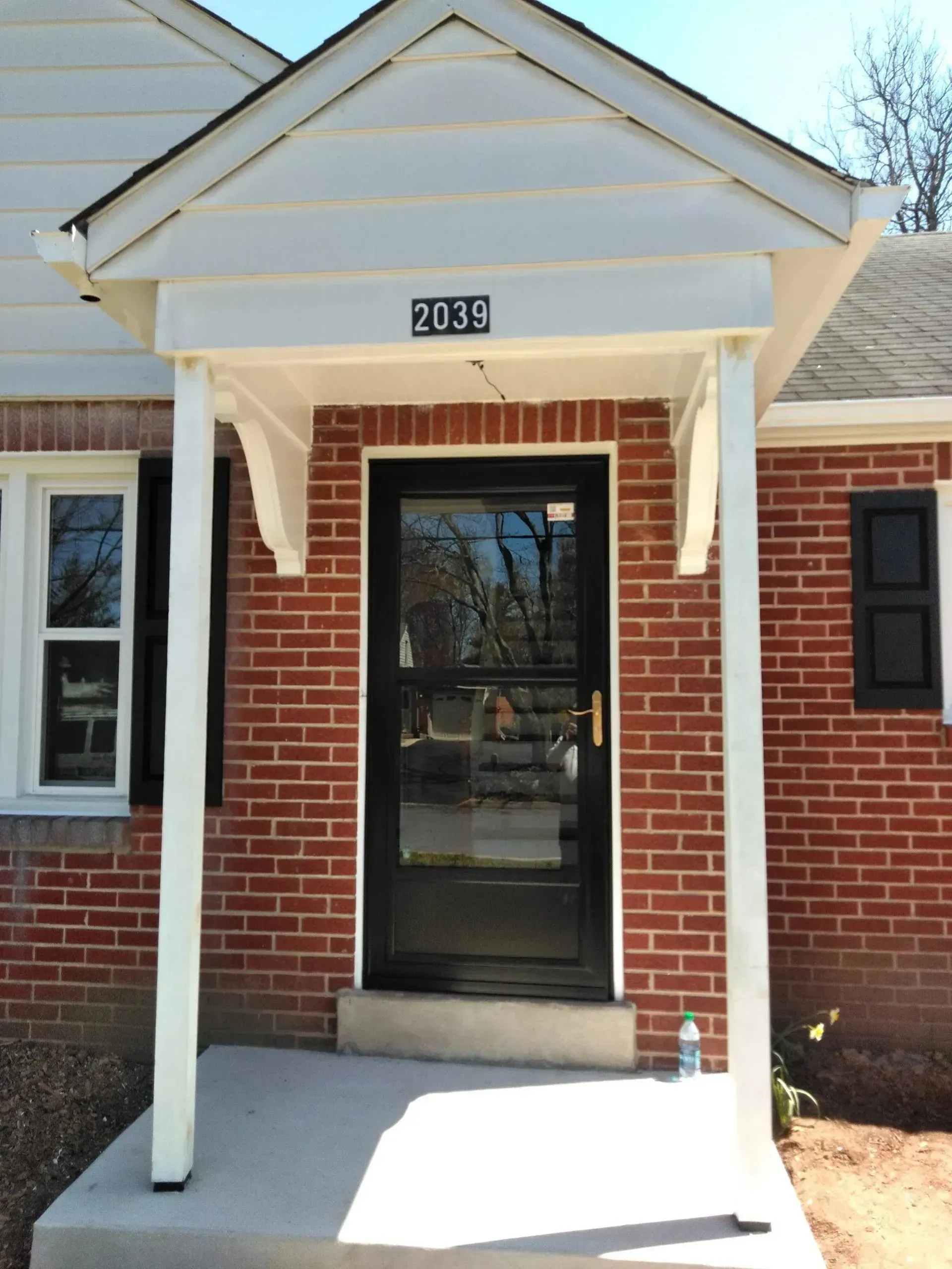 The front door of a brick house with the number 3005 on it