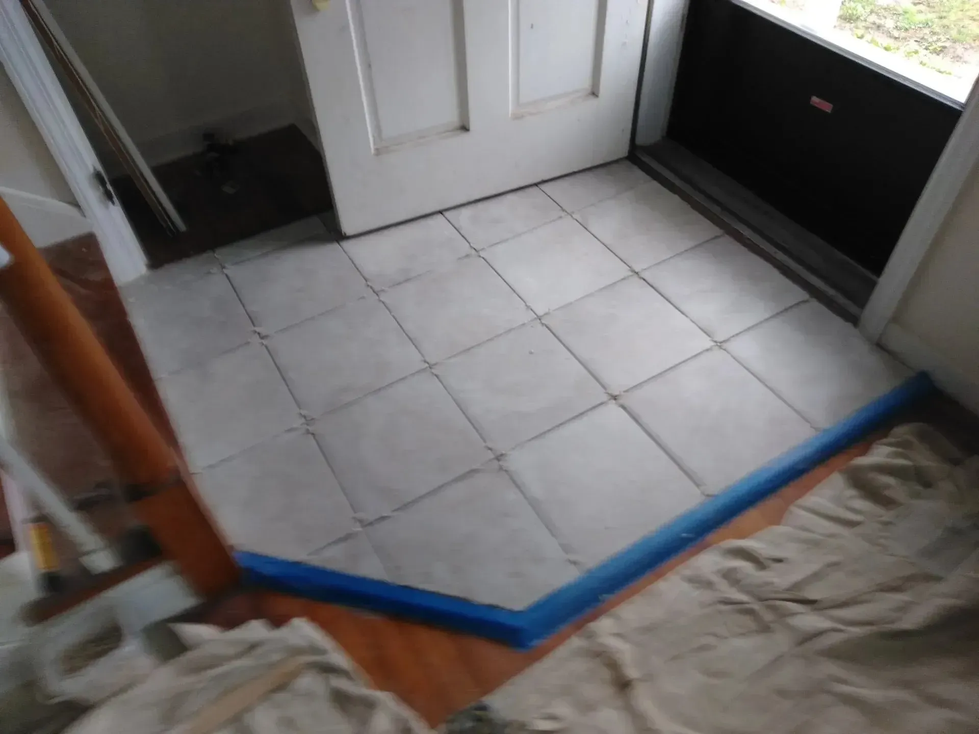 A tiled floor with a blue tape around it