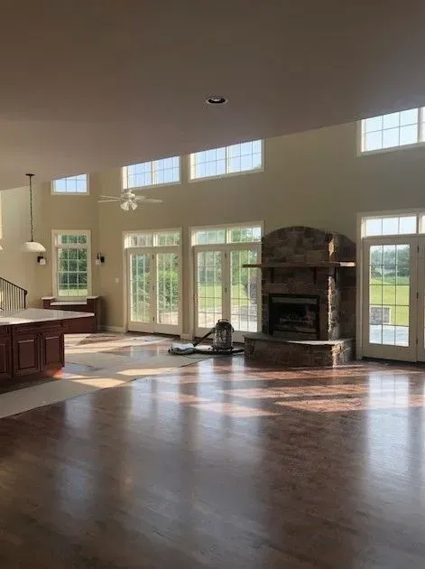 A large empty living room with hardwood floors and a fireplace.